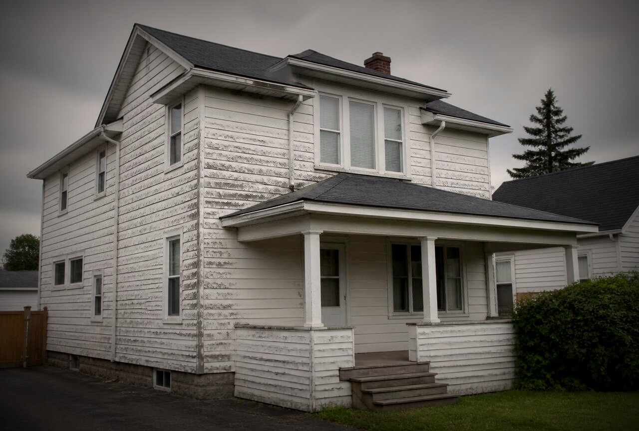 House with peeling faded siding before exterior painting